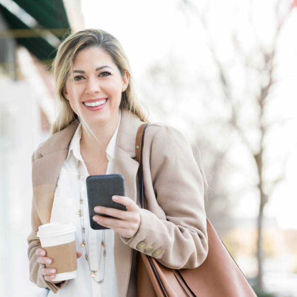 istock Beautiful woman uses smart phone while outdoors 918377916
