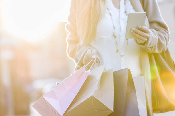 istock Woman uses smart phone while shopping 918377970