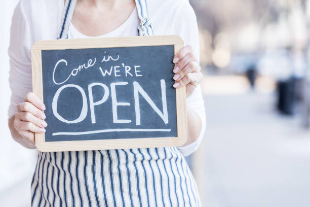 istock Cafe owner holding 'open' sign outdoors 918377976