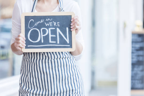 istock Restaurant owner holding 'Open' sign 918377978