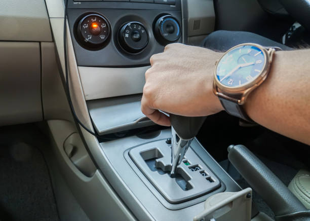 gros plan homme avec hold montre la voiture vitesse pendant que vous conduisez la voiture pour travailler - car driving men reversing photos et images de collection