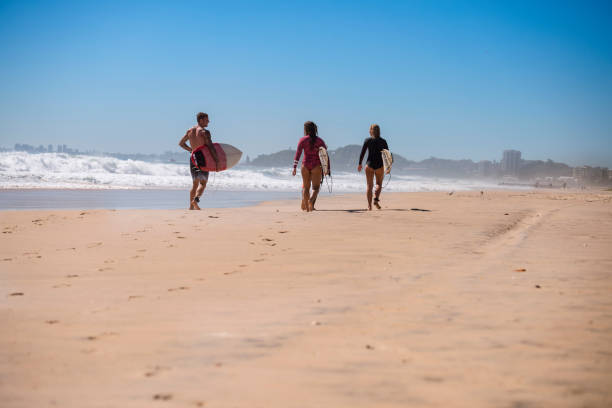 istock Friends walking along the coast with surfboards 918380834