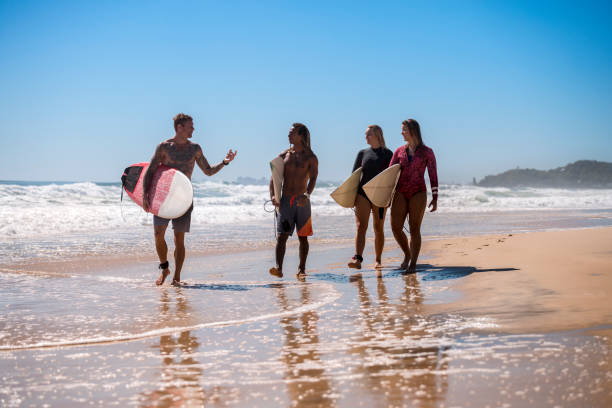 istock Friends walking along the coast with surfboards 918380844