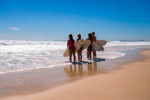 istock Friends stand on the coast and wait for high surfing waves 918380876