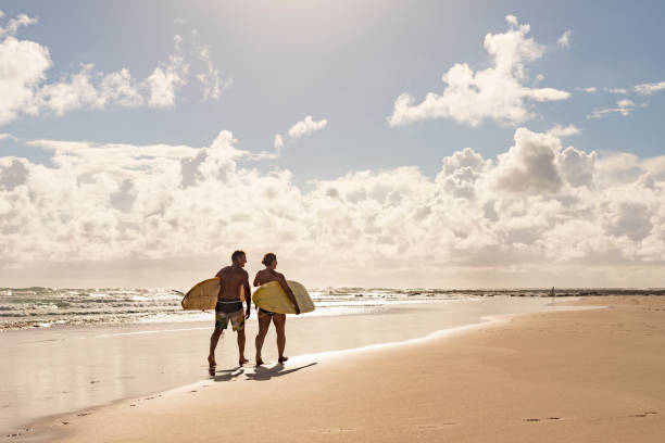 Middle Aged Couple With Malibu Longboard Surfboards