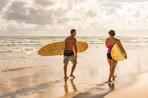 istock Middle Aged Couple With Malibu Longboard Surfboards 918380982