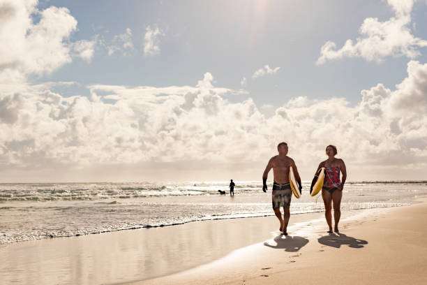 istock Middle Aged Couple With Malibu Longboard Surfboards 918380986