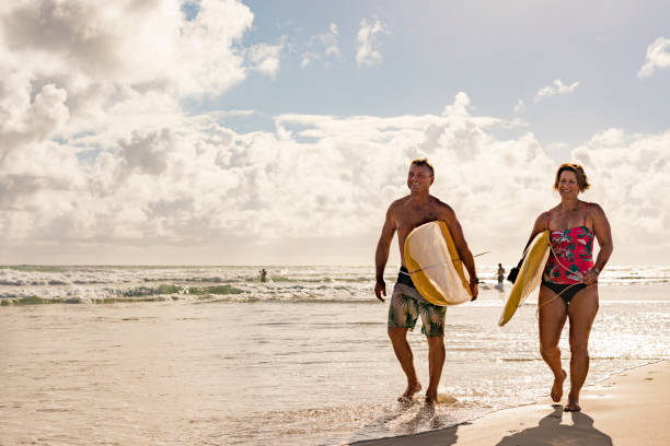 istock Middle Aged Couple With Malibu Longboard Surfboards 918380990
