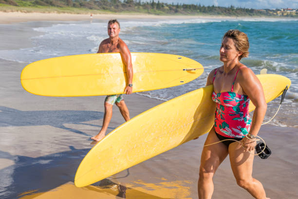 istock Middle Aged Couple With Malibu Longboard Surfboards 918381014