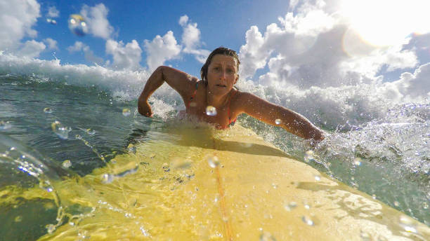 pov imagem de meio envelhecido mulher surf na praia - full length one person action australian culture - fotografias e filmes do acervo