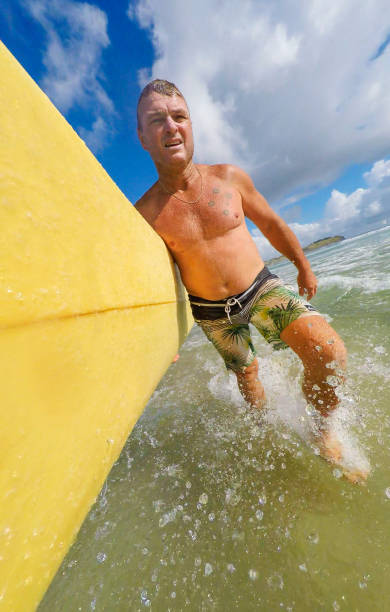 pov imagem de meio envelhecido homem surf na praia - full length one person action australian culture - fotografias e filmes do acervo