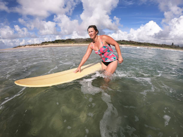 istock Middle Aged Woman Surfing at the Beach 918382044