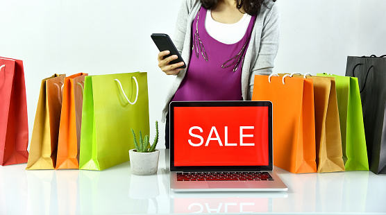 Online shopping, Shopaholic woman with sale promotion sign on laptop computer, E-business commercial concept.