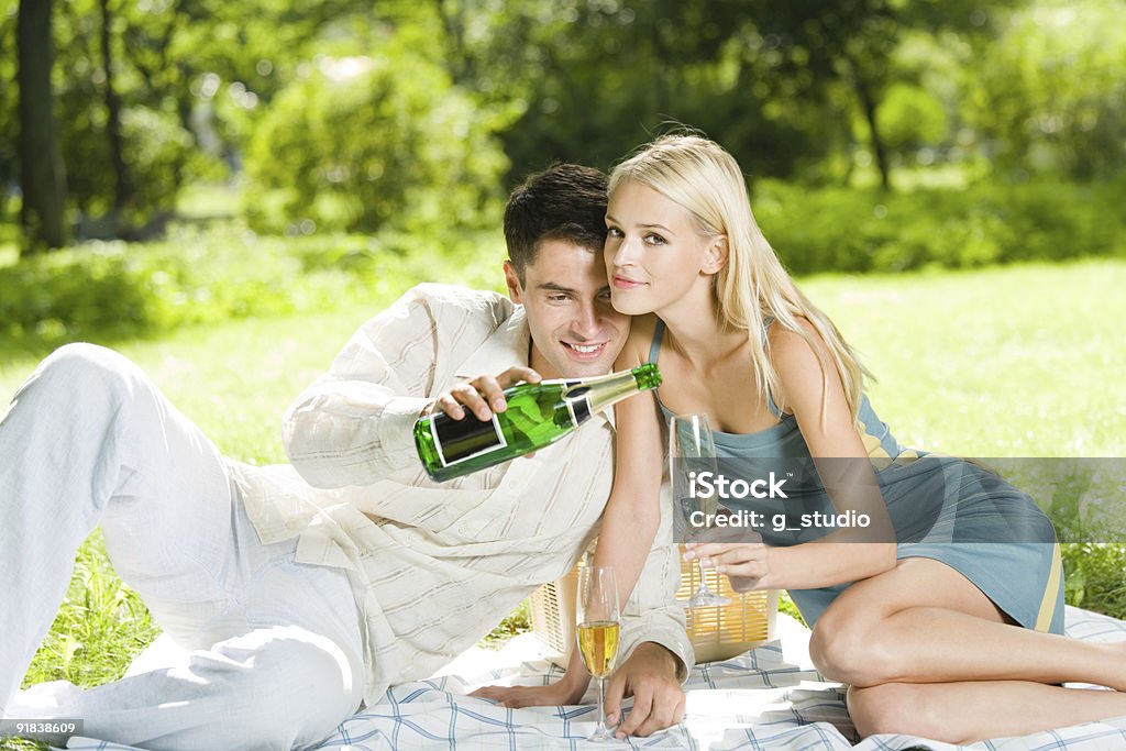 若い幸せなカップルには、お祝いのシャンペンピクニック - 20-24歳のロイヤリティフリーストックフォト