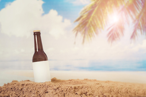 Blank Logo Beer bottle in the sand with beach background