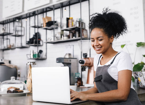 istock Young cafe owner working on her laptop, standing at counter 918392170