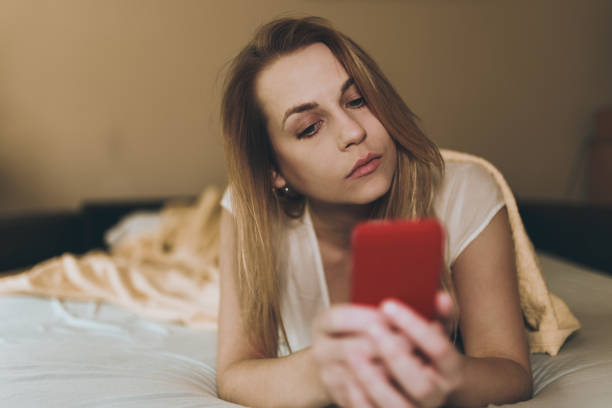 istock Young woman using phone in bed in the morning 918396356
