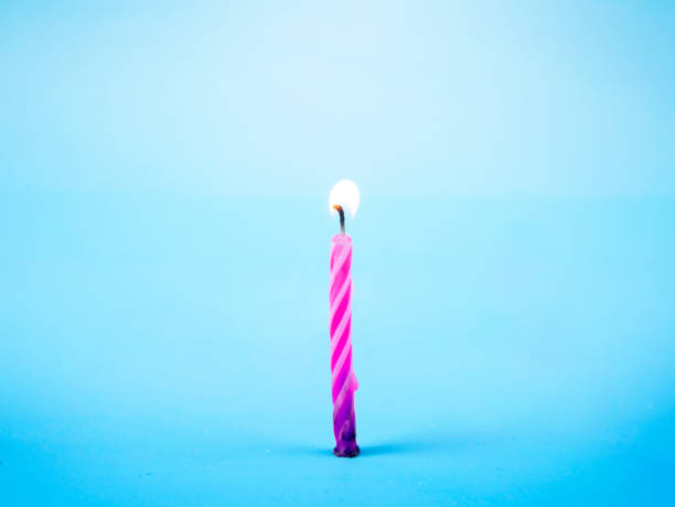 istock Colorful one candle illumination on sky blue background 918402836