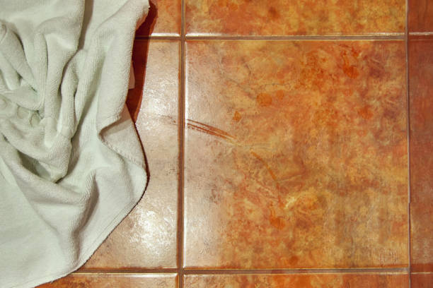 istock Copy space. Wet creased white towel on ceramic floor in bathroom. Ceramic tile warm colors. For background. 918403164