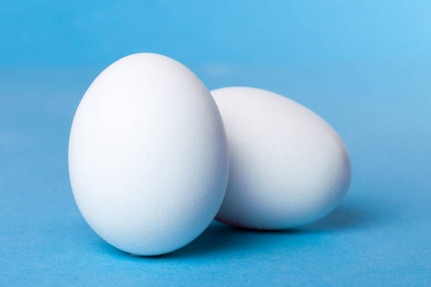 istock Good hearty breakfast of boiled eggs. Two white eggs on a blue background 918406346