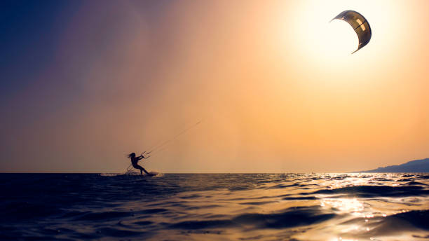 istock Silhouette of a kiteboarder against the sun 918407304