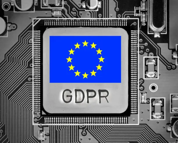 Macro photo of circuit board and chip with EU flag and GDPR letters imprinted on metal surface