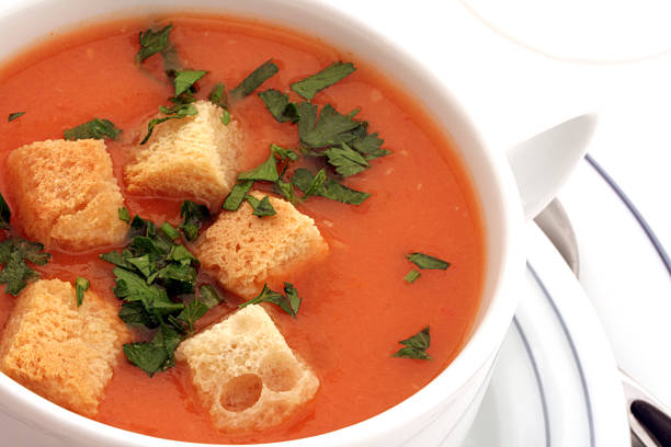 Tomato soup with croutons in ceramic bowl on white stock photo