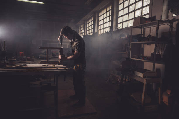 male carpenter using drill to repair a chair in a workshop. - craft craftsperson photography indoors imagens e fotografias de stock