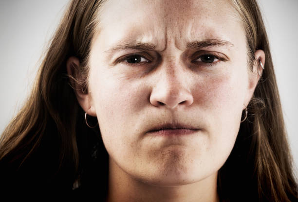 A young woman glares at the camera looking fierce, rebellious and determined.