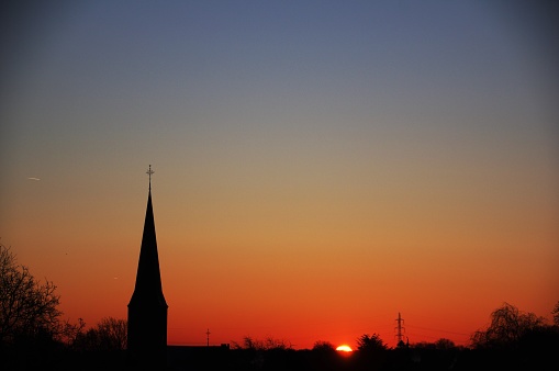 Daybreak over the village with clock tower in silhouette