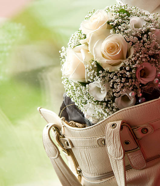 Wedding bouquet in female handbag stock photo