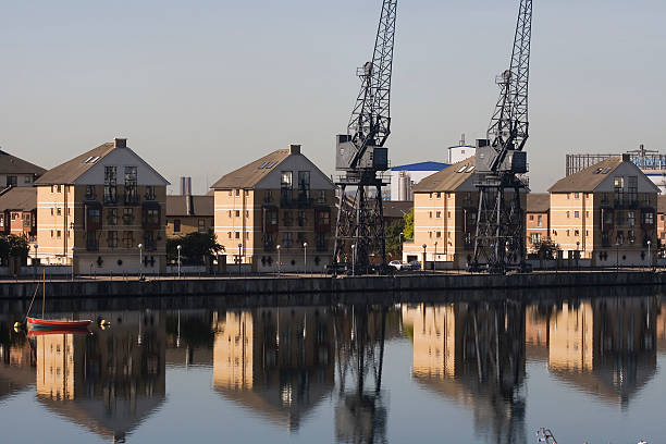 istock Cranes and houses reflected on river Thames, London 91842494