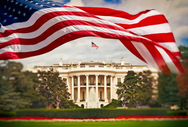 Photo of The White House with waving American flag