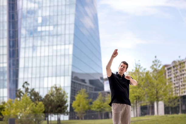 istock Man Making Hand Gestures in Front of Glass Building 918427818