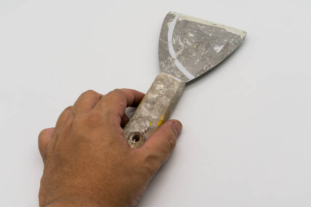 istock Hand holding used dirty Construction / Circular trowel isolated on white background 918427928