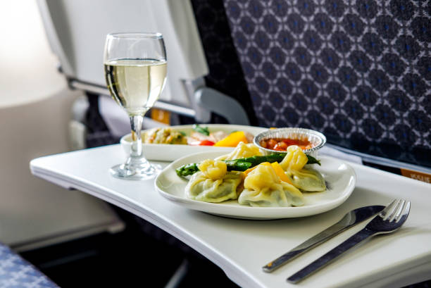 leckere mahlzeit an bord des flugzeugs auf dem tisch - commercial airplane airplane business travel flying stock-fotos und bilder