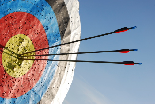 Three arrows in the centre of an archery target