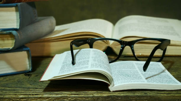 istock Open Bible with Glasses on the Old Table. 918434422