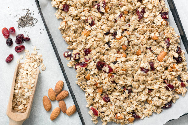 istock Homemade granola on baking sheet and ingredients. Top view 918440182