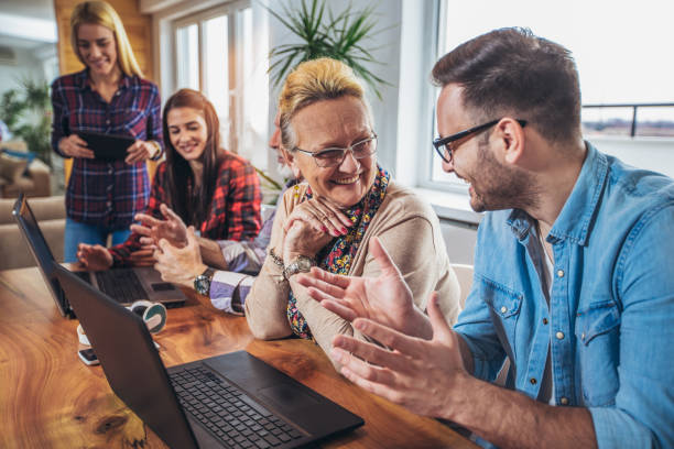 istock Young volunteers help senior people on the computer 918443604
