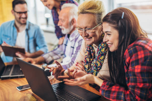 istock Young volunteers help senior people on the computer 918444000