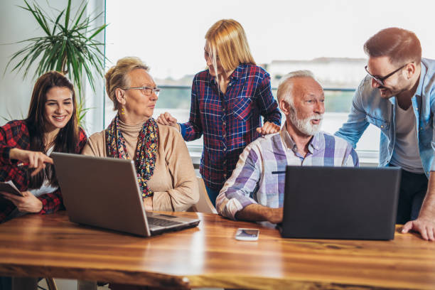 istock Young volunteers help senior people on the computer 918444654