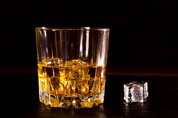 istock Whiskey drink on wooden table over dark background 918447752