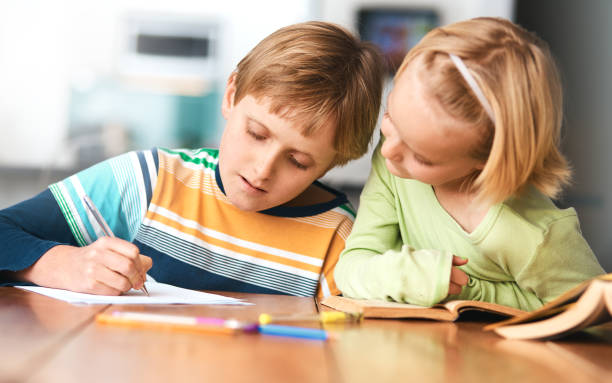 istock Blonde brother and sister doing homework together 918450382