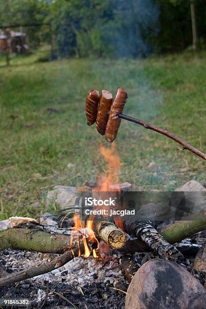 Photo libre de droit de Susages Sur Feu De Camp banque d'images et plus d'images libres de droit de Saucisse - Saucisse, Bâton de bois, Rôti à la broche