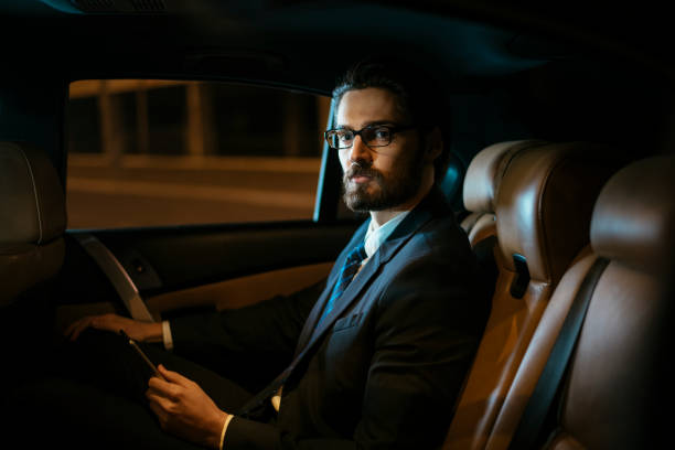 istock Serious businessman working in car 918458780