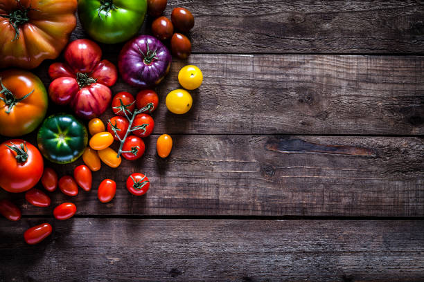 fronteira de variedades de tomate na mesa de madeira rústica - heirloom tomato organic tomato rustic - fotografias e filmes do acervo
