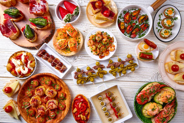 Tapas mix and pinchos food from Spain Tapas mix and pinchos food from Spain recipes also pintxos on a white wood board mediterranean food photos stock pictures, royalty-free photos & images