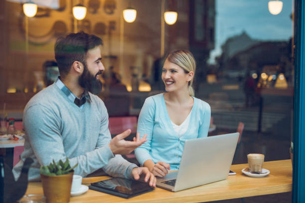 istock Happy couple sitting in cafe with laptop and web surfing 918477730