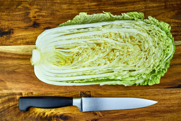 istock Chinese leaf lettuce, cut in half, and chef knife on a wooden board 918480578